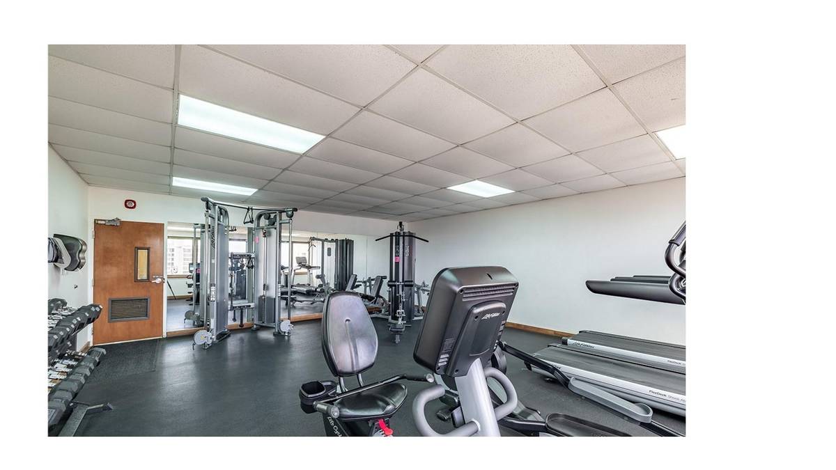 A gym with a variety of equipment including weights and cardio machines.
